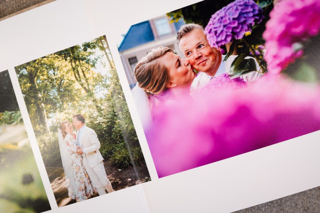 Trouwfoto's van een bruidspaar in een fotoboek, met een close-up van kleurrijke hortensia's en intieme momenten.
