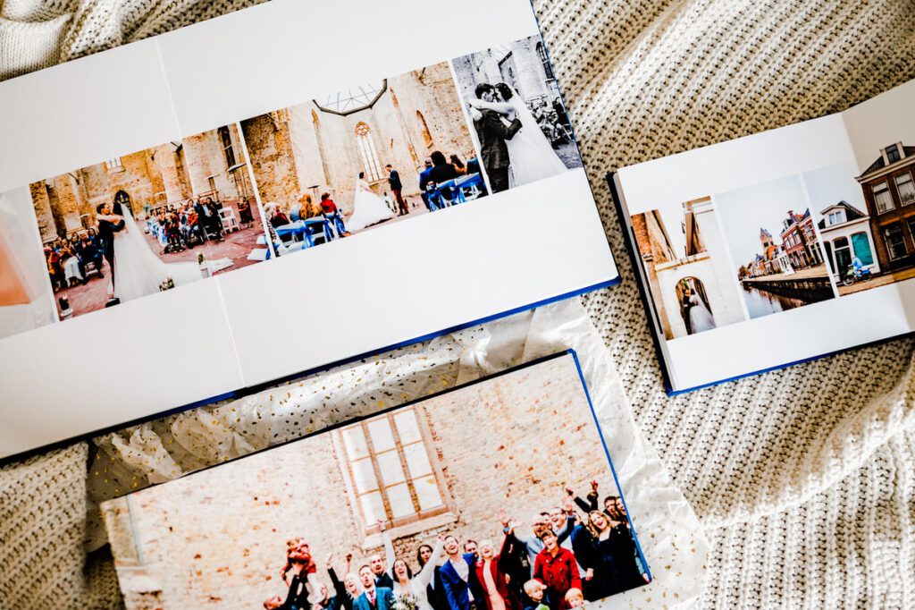 Open fotoboek met trouwfoto's van een ceremonie en feest, geplaatst op een zachte, gezellige achtergrond.